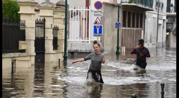 Two women walk through the flooded streets of Montargis, France, south of Paris, on June 1, 2016. Photo: Dominique Faget, AFP, Getty Iamges