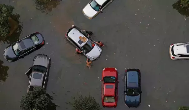 Vehicles are submerged in floodwaters on July 9, 2016 in Wuhan, Hubei Province of China. Many parts of the Wuhan area were submerged in floodwaters during July as torrential rains affected the Yangtze River valley. A new study finds that climate change increased the risk of the rains that led to the flooding by 17 – 59%. Photo: VCG/VCG via Getty Images.