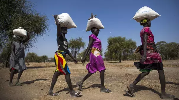 Women carry food in gunny bags after visiting an aid distribution center in South Sudan on March 10. Photo: Albert Gonzalez Farran, AFP, Getty Images