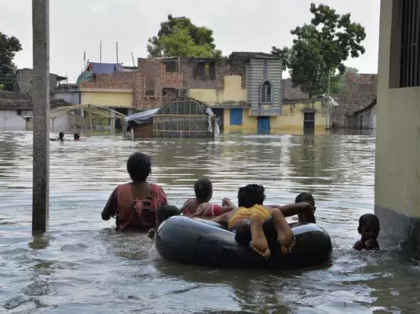 Indian residents wade through flood waters in Malda in the Indian state of West Bengal. Photo: AFP
