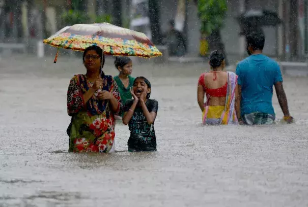 People wade through a flooded street in Mumbai, India, on August 29th, 2017. Photo: Punit Paranjpe, AFP/Getty Images