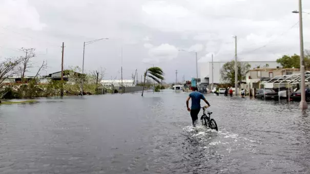 A man pushes his bicycle through a flooded street in Cataño, Puerto Rico, on Friday. Hurricane Maria drenched many spots on the island with about 20 inches of rain. Photo: Ricardo Arduengo/AFP/Getty Images