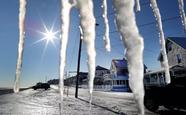 Icicles hang from a porch on Ocean Street as cleanup takes place in the Brant Rock section of Marshfield, MA, following a winter storm that flooded much of the area the previous day, on Jan. 5, 2018. Photo: John Tlumacki, The Boston Globe via Getty Images