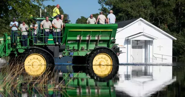 Workers use farm machinery to navigate floodwaters from the Waccamaw River caused by Hurricane Florence in Bucksport, South Carolina. Sea-level rise exacerbated flooding from the storm. Photo: Sean Rayford, Getty Images