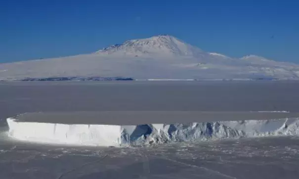An iceberg lies in the Ross Sea with Mount Erebus in the background near McMurdo Station in Antarctica, November 11, 2016. A sheet of meltwater lasted for as long as 15 days in some places on the surface of the Ross Ice Shelf, the largest floating ice platform on Earth, during the Antarctic summer of 2016. Photo: Agence France-Presse via Getty Images