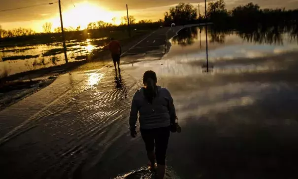 Melissa Martinez and her son, Fernando Martinez wade away from the flooded area in Gridley, California. Photo: Marcus Yam, Los Angeles Times via Getty Images