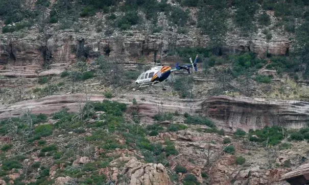 A helicopter flies above the rugged terrain along the banks of the East Verde River during a search and rescue operation for victims of a flash flood, July 16, 2017, in Payson, Ariz. Photo: ABC News