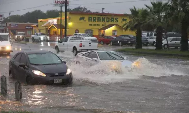 Traffic moves around a vehicle stalled in high water at the intersection of West Military Drive and Westbriar, Monday, August 7, 2017. Photo: Jerry Lara, San Antonio Express-News