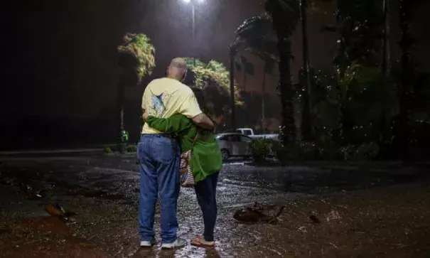 Tony Buchanan and Myava Buchanan watching heavy rain and winds from Hurricane Harvey on Friday night from a hotel in Corpus Christi, Tex. They had been evacuated from Aransas Pass, Tex. Photo: Tamir Kalifa, The New York Times