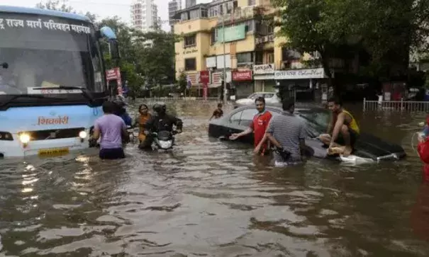 Commuters make their way through a flooded street following heavy rains in Mumbai, India, Aug. 29, 2017. Photo: Rajanish Kakade, AP