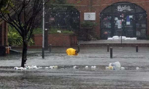 A worker tries to clean a drain in the Market in Charleston Monday afternoon. Photo: Brad Nettles, Charleston Post and Courier