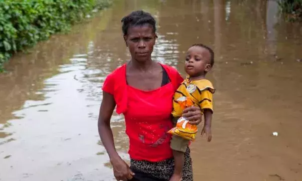 A woman carries her infant son across the flood waters of Hurricane Irma, in Fort-Liberte, Haiti, Friday Sept. 8, 2017. Irma rolled past the Dominican Republic and Haiti and battered the Turks and Caicos Islands with waves as high as 20 feet (6 meters). Photo: Dieu Nalio Chery, AP