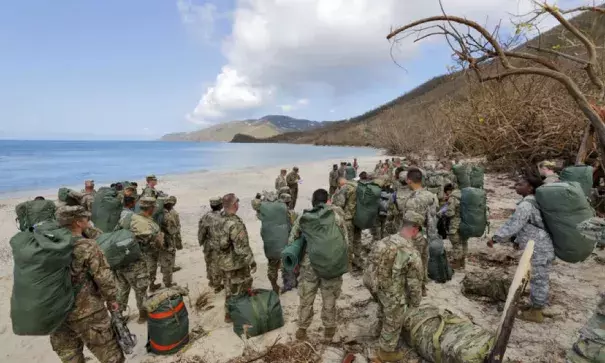 Army soldiers from the 602nd Area Support Medical Company gather on a beach as they await transport on a Navy landing craft while evacuating in advance of Hurricane Maria, in Charlotte Amalie, St. Thomas, U.S. Virgin Islands, Sept.17, 2017. Photo: Jonathan Drake, Reuters