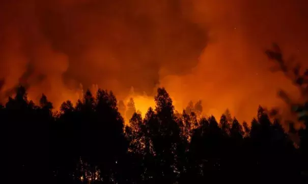 Smoke and flames from a forest fire are seen near Lousa, Portugal, October 16, 2017. Photo: Pedro Nunes, Reuters