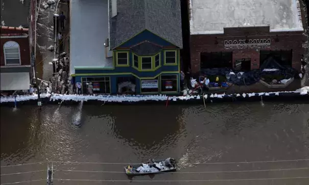 A boat carrying sandbags moves down South Central Avenue on Tuesday, May 2, 2017. As the floodwater from the Meramec River approached a record crest, the sandbags appeared to be holding back the water. Photo: David Carson, St. Louis Post-Dispatch