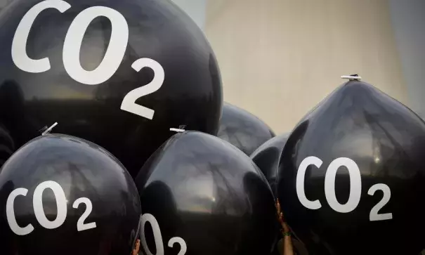 Activists hold giant balloons labeled ‘CO2’ in front of the Neurath coal power plant ahead of the Bonn climate summit. Photo: Philipp Guelland, EPA