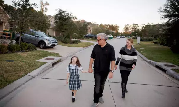 Leslie Martinez, right; her husband, John Ahearn; and their daughter, Alex Ahearn, outside their home, which flooded after Hurricane Harvey despite being outside the official flood plain in The Woodlands, Tex. Photo: Ilana Panich-Linsman for The New York Times