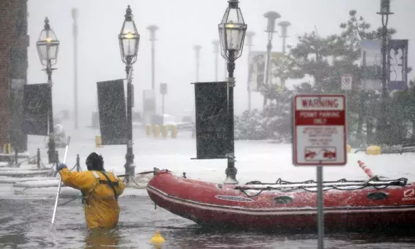 A firefighter wades through waters from Boston Harbor, which flooded on to Long Wharf on 4 January 2018. Photo: Michael Dwyer, AP