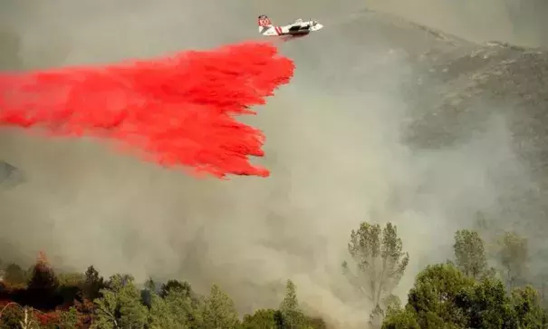 An air tanker drops retardant on a wildfire burning above the Spring Lakes community on Sunday, June 24, 2018, near Clearlake Oaks, Calif. Wind-driven wildfires destroyed buildings and threatened hundreds of others Sunday as they raced across dry brush in rural Northern California. Photo: Noah Berger, AP