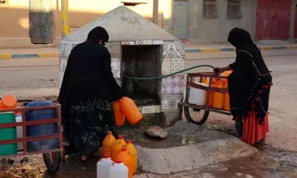 Women fill containers with water from a hose in Zagora, Morocco. Experts blame poor choices in agriculture, population growth and climate change for water shortages. Photo: Issam Oukhouya, Associated Press