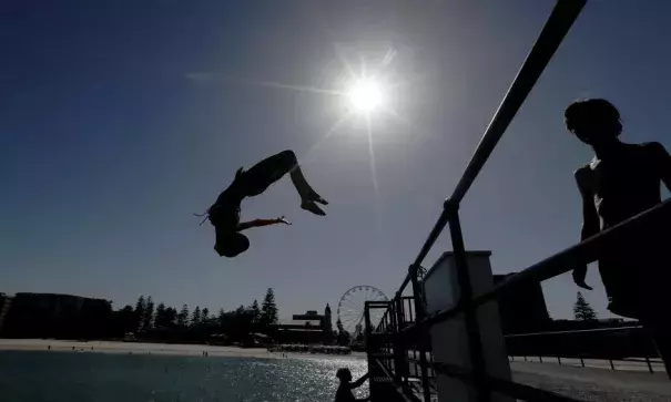 People in Adelaide head to the beach to escape Thursday’s record-breaking Australia heatwave. Photo: Kelly Barnes, AAP