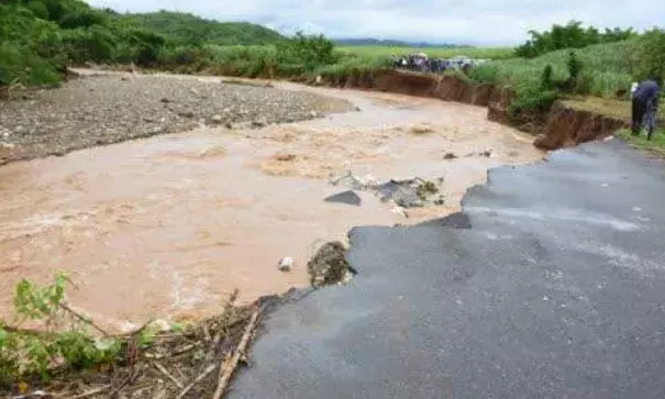 This is what is left of the Guy's Hill main road after flood waters converted it into a river yesterday. Photo: Garfield Robinson