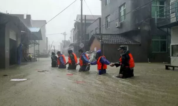 Rescue workers walk on a flooded street at a town hit by Typhoon Soudelor in China's Fujian province. Photo: Reuters, China Out