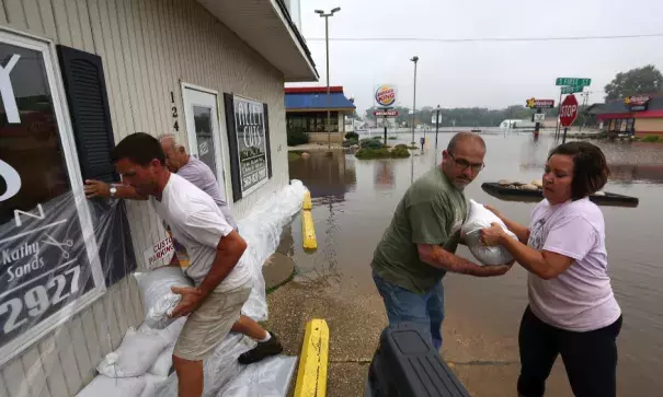 Holly Cole, right, and Michael Ridenou, second from right, work to build sandbag walls at the Alley Cuts on Main building along West Main Street Friday, Sept. 23, 2016, in Manchester. Photo: Jessica Reilly, Dubuque Telegraph-Herald AP