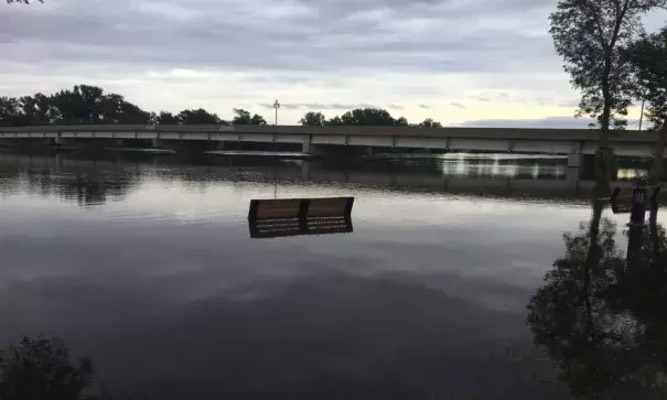 A park bench is rendered useless as the Cedar River continues its rise. Photo: Connor Morgan - KGAN