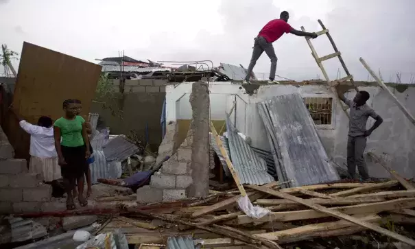 Residents repair their homes destroyed by Hurricane Matthew in Les Cayes. Photo: Dieu Nalio Chery/AP