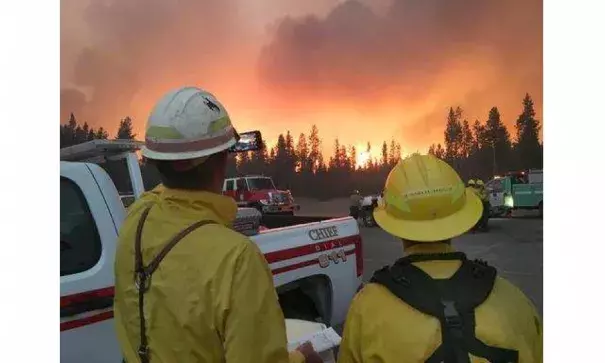 In this Sunday, Sept. 11, 2016 photo, firefighters observe a wildfire's push to the northeast, after initiating sprinkler systems to protect structures around Headwaters Lodge at Flagg Ranch in Moran, Wyo. Photo: National Park Service