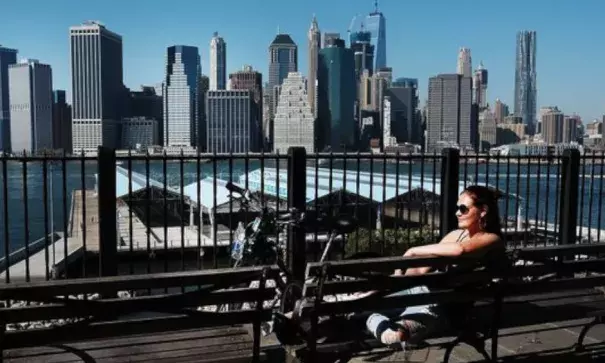 A woman sits in the sun on a summerlike day on Oct. 18, 2016, in the Brooklyn borough of New York City. New York and much of the East Coast are experiencing an Indian summer as temperatures reach into the high 70s. Photo: Spencer Platt, Getty Images