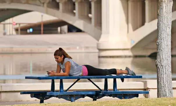 A woman relaxes next to Tempe Town Lake as temperatures are expected to break records again in Tempe, Ariz. Arizona is in the midst of a heat wave that has made October one of the hottest on records. Photo: Ross D. Franklin, AP