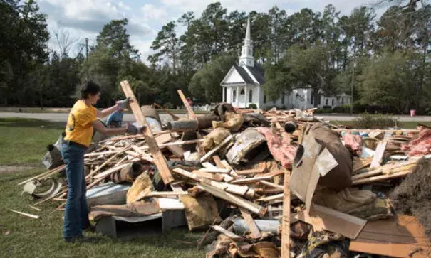 Wendy Gable, with Southern Baptist Convention Disaster Relief, throws wood onto a pile that was removed from a home that was heavily damaged by floodwaters caused by rain from Hurricane Matthew in Nichols, S.C., Thursday, Oct. 27, 2016. A stew of contaminants stood inches to feet deep in homes for a week. As it receded, toxic black mold grew rampant, leaving nearly all of the town’s 261 homes uninhabitable. Few, if any, had flood insurance. Photo: Mike Spencer