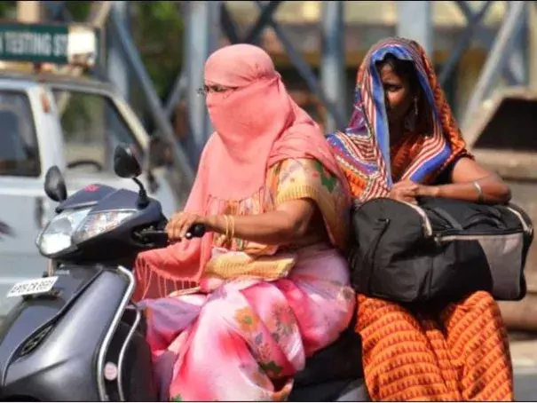 Covering their faces with a scarf and the saree's pallu, these women are trying their best to beat the heat in Vijayawada, in this April 5 picture. Photo: V. Raju, The Hindu