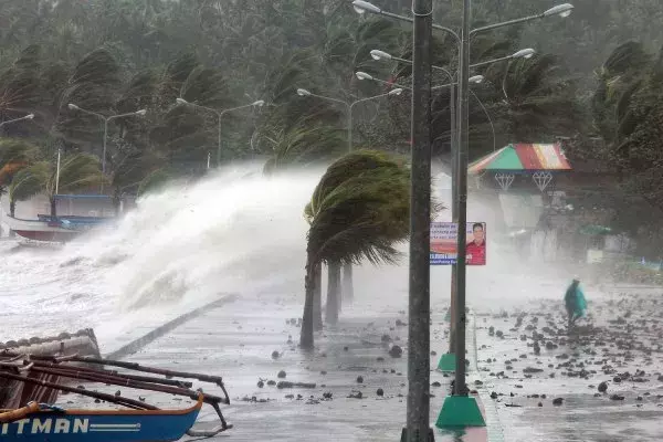 A resident walks past high waves pounding the seawall amid strong winds as Typhoon Haiyan hit the city of Legazpi, Albay province, Philippines, on Nov. 8, 2013. Photo: Charism Sayat, AFP, Getty Images