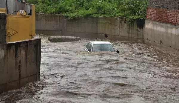 Photo: A car floating in a nala at Qutbllapur village, following heavy rain on the outskirts of Hyderabad on Wednesday. Photo: G. Ramakrishna