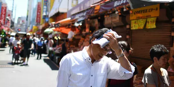 People walk in the street during a hot day in Tokyo's district of Ueno on August 7. Credit: Charly Triballeau, AFP Getty