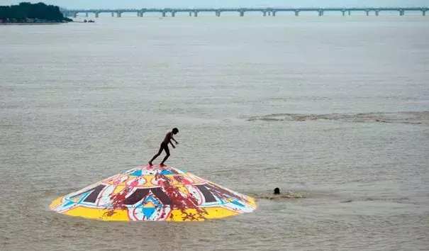 An Indian youth stands on the top of a submerged portion of Arail Ghat as he prepares to jump into the flooded Yamuna River in Allahabad, India on August 21, 2019. Monsoon flooding in India during late July and August killed at least 287 people, making it the deadliest weather-related disaster of the month. Photo: Sanjay Kanojia, AFP/Getty Images