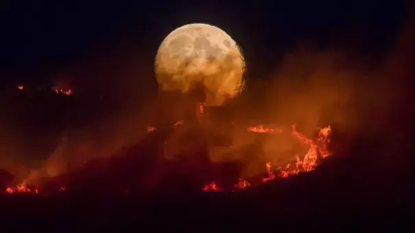 The full moon rises over the Saddleworth Moor fire. Photo: Getty