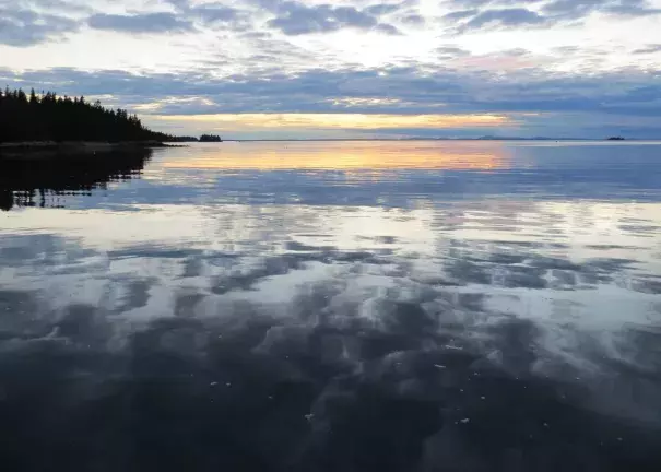 A sunset is visible aboard a schooner anchored off the coast of Isle au Haut in the Gulf of Maine. Photo: Becky Krystal, The Washington Post