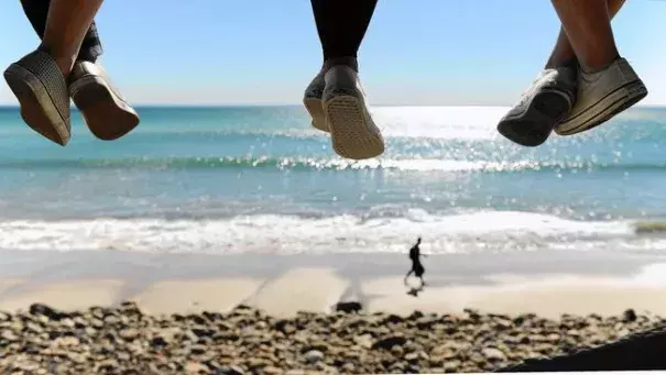 On a hot winter day in Malibu, three young girls dangle their feet from a lifeguard tower on Pacific Coast Highway. Photo: Wally Skalij, Los Angeles Times