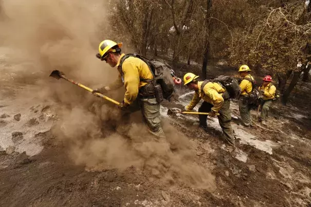 From left, firefighters Aaron Williams, Lyle Bennett, Robert Larios and Capt. Crawford Gunn, with the San Bernardino National Forest, put out hot spots Monday morning along Highway 154 in Santa Barbara County. Photo: Al Seib, Los Angeles Times