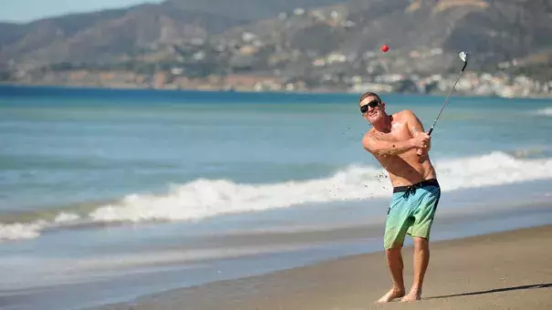 Dan Charcoal, who is vacationing in Southern California from Maui, golfs on Zuma Beach during a hot winter day Monday. Photo: Wally Skalij, Los Angeles Times