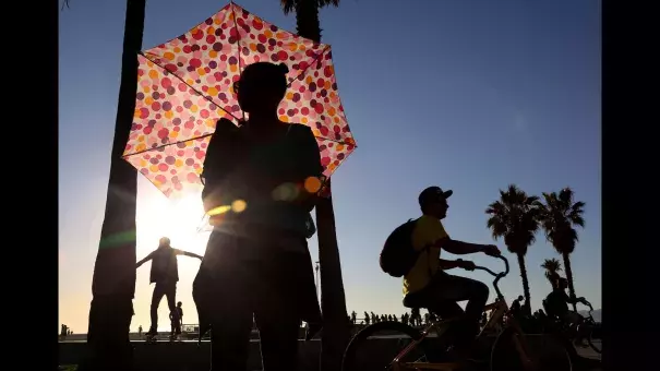 Ariel Rhone uses an umbrella for shade near the Venice boardwalk on Monday. Photo: Katie Falkenberg, Los Angeles Times