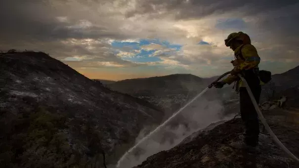 Los Angeles County firefighter Kevin Sleight extinguishes hot spots while battling the La Tuna fire. Photo: Allen J. Schaben / Los Angeles Times