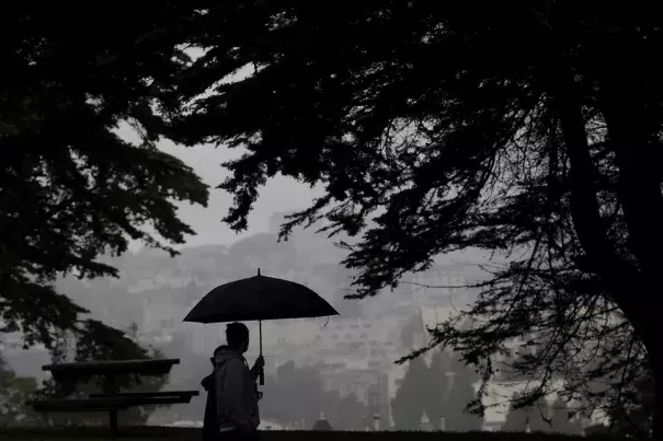 A man and a woman walk together in Alamo Square Park in San Francisco on Thursday evening. Photo: Jeff Chiu, AP