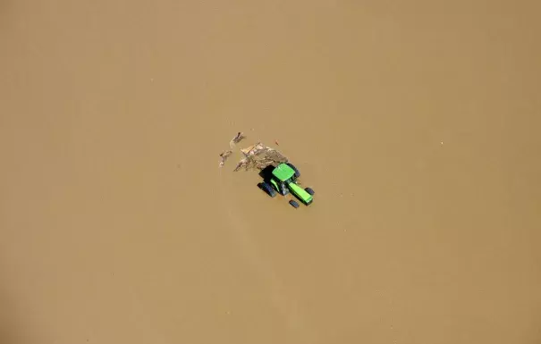 A tractor sits partially submerged in a field after flooding along the South Platte River in Weld County, Colorado near Greeley, on September 14, 2013. Photo: John Wark, AP