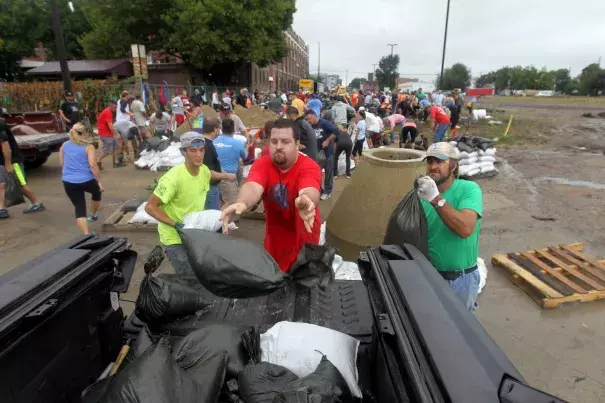 Jason Mann, of Cedar Rapids, Iowa, loads sandbags onto a truck in the New Bohemia District, on Sept. 23. Photo: David Scrivner /Iowa City Press-Citizen via AP