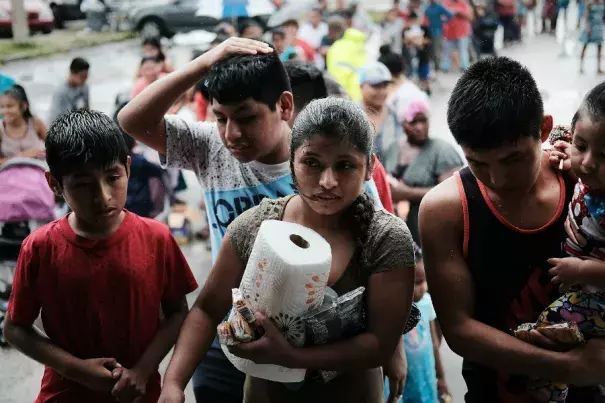 A line of residents of the rural migrant farm worker town of Immokalee, Florida, waited for emergency donations of food and supplies brought in by a volunteer group from Georgia. Hurricane Irma damaged homes, flooded their community and wiped out jobs they rely on. Photo: Spencer Platt, Getty Images